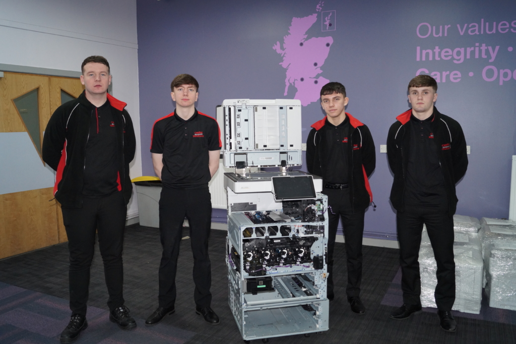 Our 4 new Apprentice Workshop Engineers beside one of our multi-functional print devices
